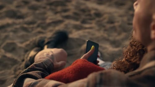 Unrecognizable Couple Enjoying Vacation Sandy Beach. Closeup Young Woman Using Smartphone In