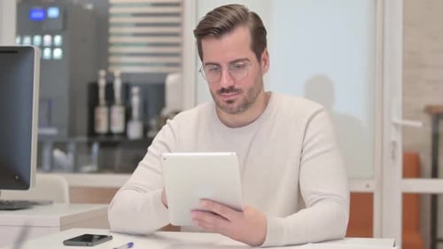 Young Man Using Digital Tablet in Office