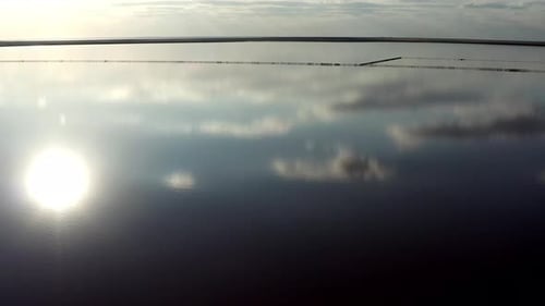 Beautiful top view of the salty, pink lake. The midday sun is reflected in the lake.