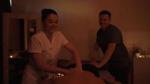 Massage Therapy With Two Professionals in Candlelit Room