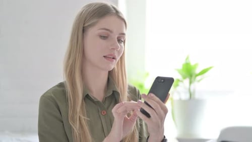 Blonde Woman Browsing Internet on Smartphone