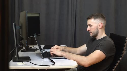 Un lugar de trabajo para programadores con varios monitores y un ordenador portátil