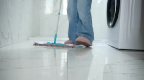 Woman Cleaning Bathroom Floor