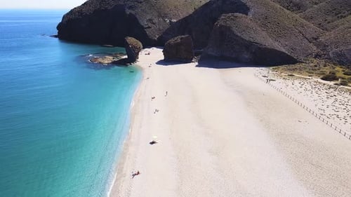 Drone aerial view of seashore, coastline, scenic view of people at unspoiled beach