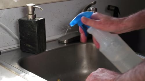 Man Hands Cleaning Surfaces By Spraying Alchohol And Rubbing Towel - Closeup Shot