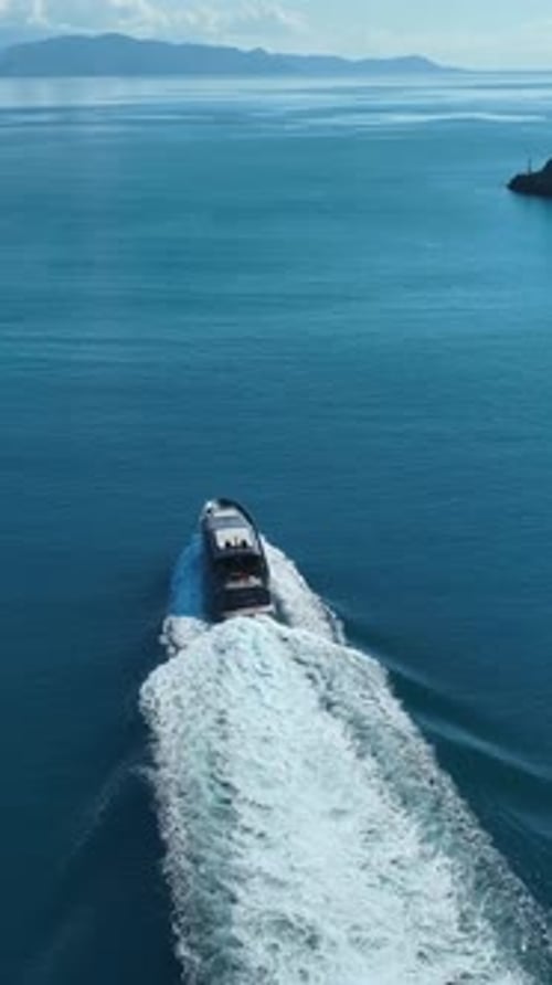 Luxury Yacht at Sea: An aerial shot of a sleek, modern yacht cutting through the serene, turquoise w