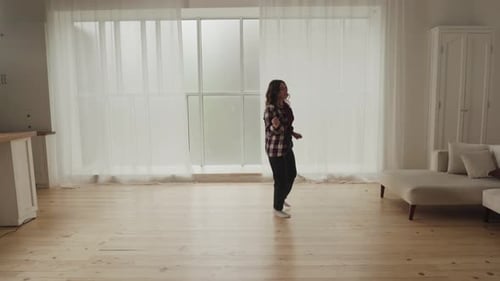 Woman Dancing Freely in Bright Living Room