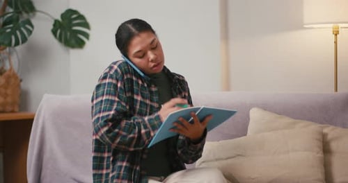Une femme hispanique écoute une explication en marquant des notes sur un bloc-notes