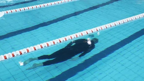 Competidor de apnea en piscina cubierta sin aleta