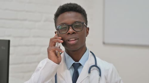 Young Doctor Talking on Phone in Office
