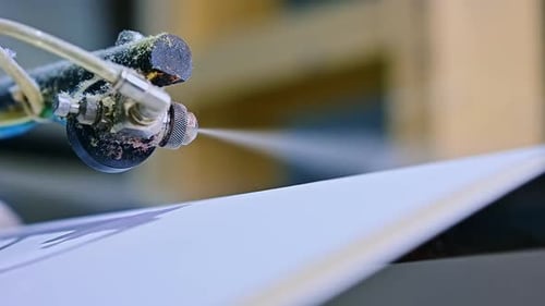 Diapers manufacturing plant. Special mechanism spraying the layer. Close up.