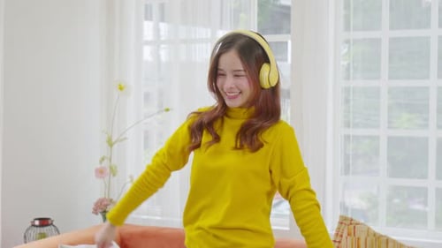 Happy Woman Dancing at Home with Headphones On