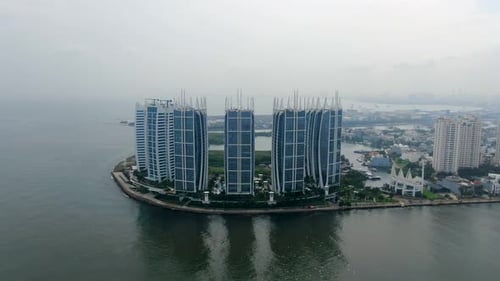 Aerial parallax of Regatta buildings by sea on cloudy day, Indonesia