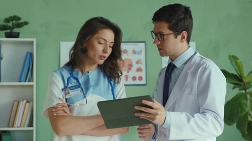 Doctors Collaborating and Reviewing Information on Tablet