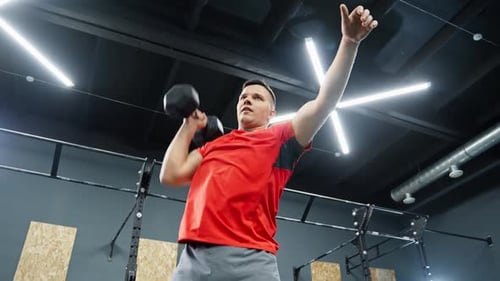 Junger Mann hebt Hantel während seines Trainings Fit Man trainiert im Fitnessstudio