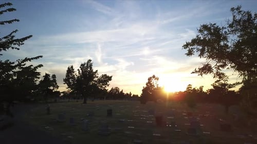 Aerial dolly shot through a small graveyard in Georgia during sunset
