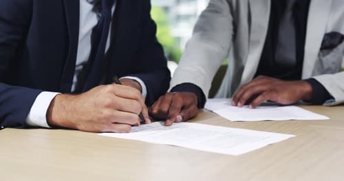 4k video footage of two unrecognizable businesspeople signing a contract in their office