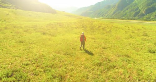 Flight Over Backpack Hiking Tourist Walking Across Green Mountain Field Huge Rural Valley at Summer