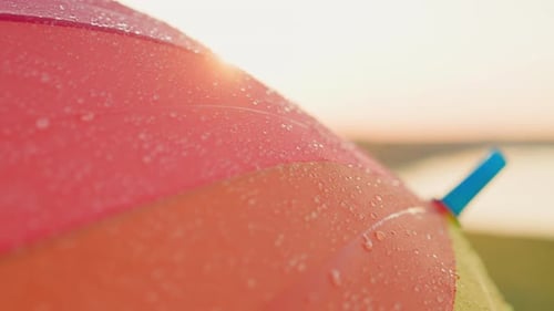 Colorful Umbrella Shimmers with Droplets at Sunset