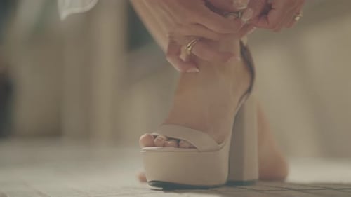 Close-Up of Woman Fastening Elegant High-Heeled Sandal. Fashion and Style Concept.