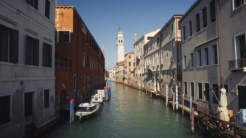 Motorboats and Wooden Piers on Grand Canal with Historical Buildings in Venice