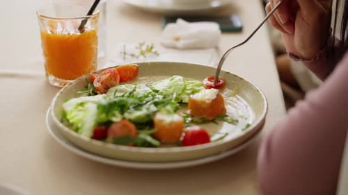 Woman Eating Healthy Salad with Orange Juice