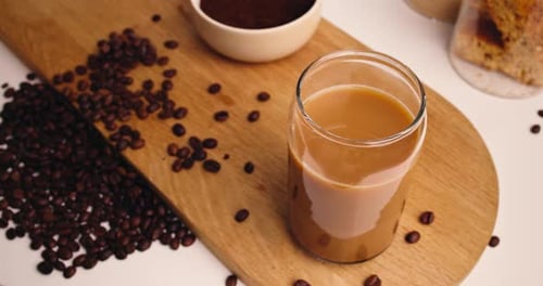 Coffee with Milk in Glass on Wooden Board