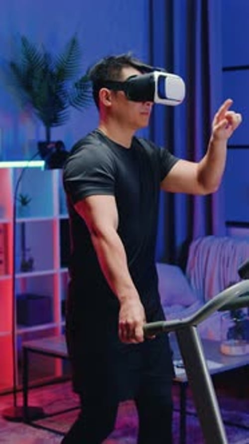 Man Walks on Treadmill Wearing VR Headset at Home