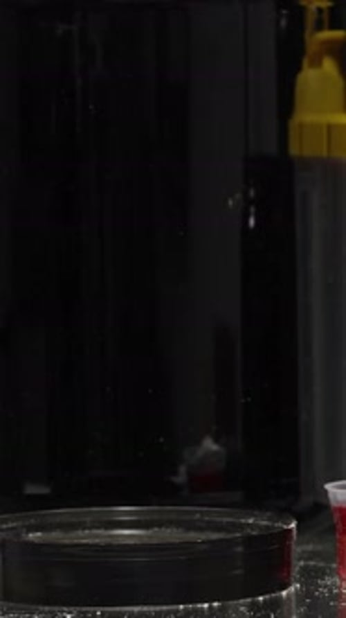 Vertical video. A Man Puts A Spoon Of Protein Powder On The Table Next To Other Supplements And