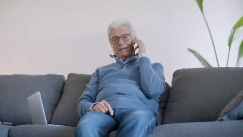 Senior Man Chatting on Smartphone at Home