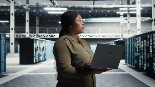 Data Center Technician Runs Equipment Checkups Using Green Screen Laptop