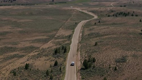 Camper on a Serene Dirt Road in the Vast Landscape Signifying Solitude