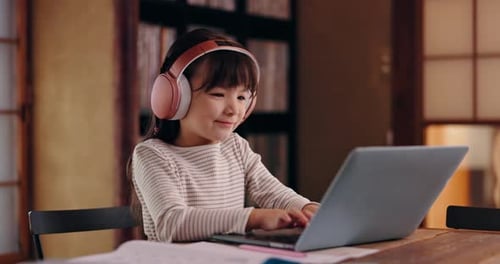 Child with Headphones Working on Laptop at Home