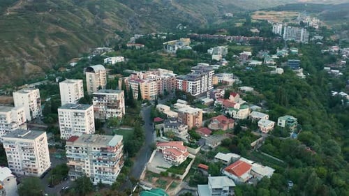 Aerial view of a green lush neighbourhood in outskirt hills of Tbilisi, Georgia. Forward close up m