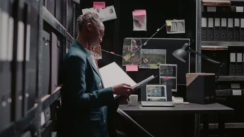 Female Detective Reviews Evidence in a Dark Office