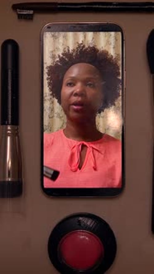 Makeup Still Life with Phone Displaying Woman