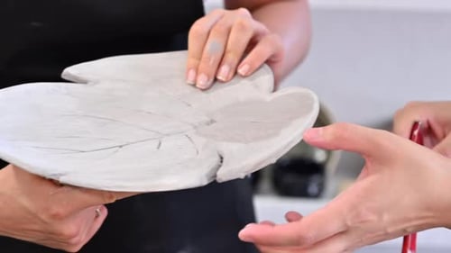 Woman painting a flower vase at pottery workshop