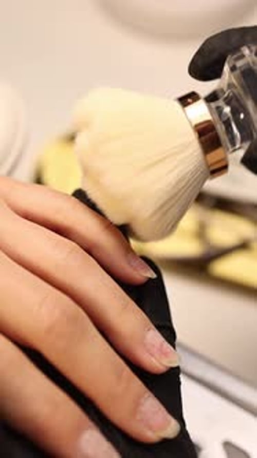 Woman getting manicure with brush in studio