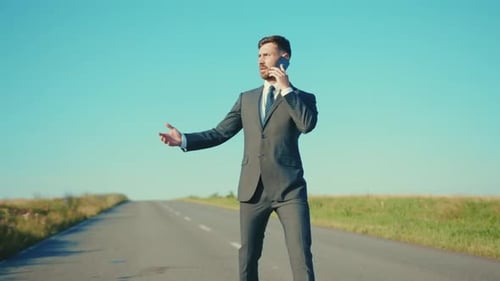 Nervous Businessman Talking on a Smartphone Walking Country Road Near a Wheat Field Freedom Concept