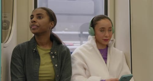 Two Young Women Ride on Public Transportation