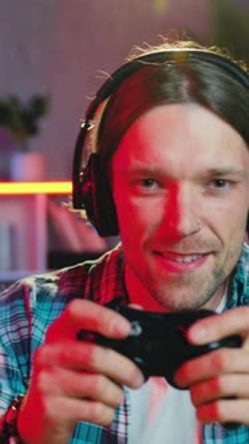 Excited Man Plays Video Game with Controller and Headset