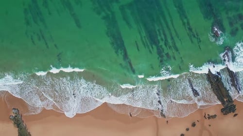 Aerial Green Sea Water Crashing Sandy Beach Drone View Foaming Waves Caressing