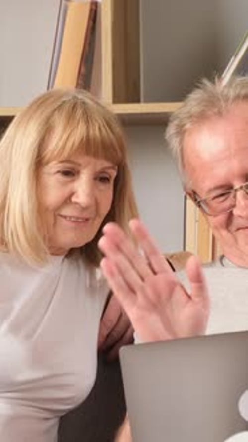 Senior Couple Video Chatting on Laptop at Home