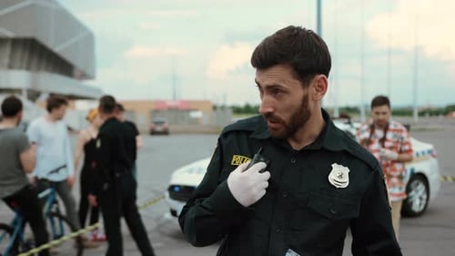 Police Officer Communicating on Walkie Talkie at Crime Scene