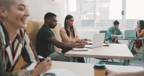 Group of diverse businesspeople working in a cafe sitting at a table together