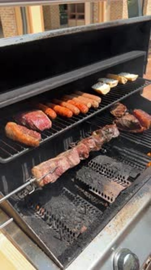 Gartengrill mit Steaks, Würstchen und Brot