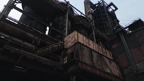 Low angle view of the abandoned structure of the former blast furnace buildings. Slow panning camera
