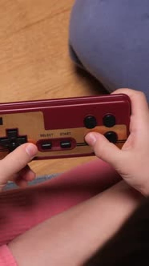 Child Playing Handheld Video Game Close Up