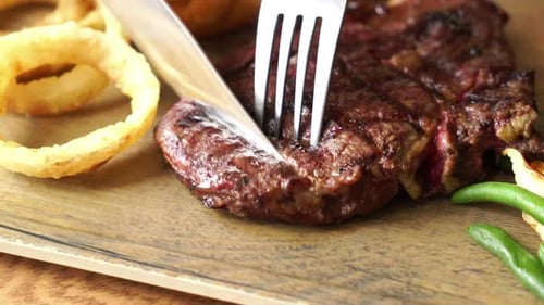 Close-Up of Steak Being Cut on Cutting Board