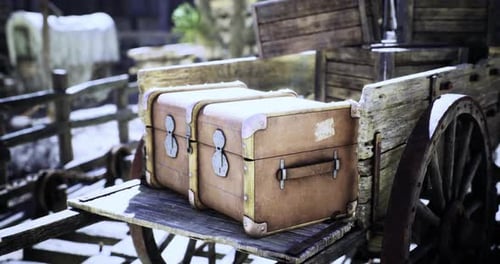Retro Travel Trunks on Wooden Cart in Snowy Scene